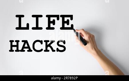 Femme écrivant des mots Life Hacks avec marqueur sur le tableau blanc, gros plan Banque D'Images