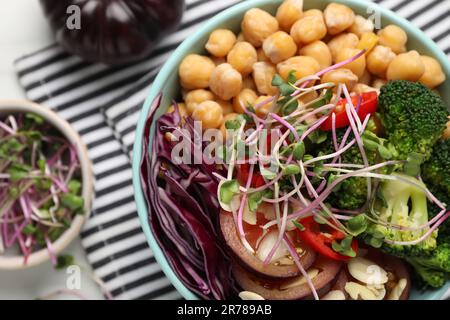 Délicieux bol végétalien avec brocoli, chou rouge et pois chiches sur table blanche, plat Banque D'Images