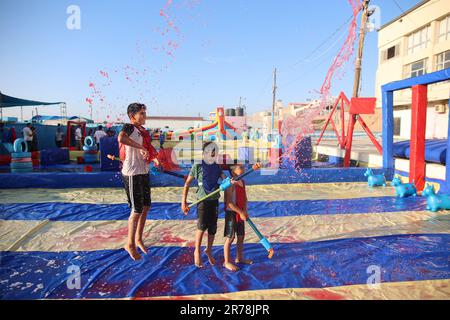 Gaza, Palestine. 12th juin 2023. Les enfants palestiniens jouent avec de l'eau colorée dans la première ville de jeux d'eau. Les hommes d'affaires palestiniens ont fondé la première ville de jeux d'eau de la bande de Gaza. Les Palestiniens ont souffert d'un manque de lieux de divertissement en raison du blocus israélien et des conditions économiques et politiques complexes rencontrées par les habitants de la bande de Gaza. Crédit : SOPA Images Limited/Alamy Live News Banque D'Images