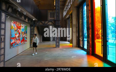 Shenyang, province chinoise de Liaoning. 7th juillet 2021. Un visiteur regarde un tableau dans une galerie d'art du parc industriel culturel et créatif de Hongmei, qui est transformé d'une ancienne usine, à Shenyang, capitale de la province de Liaoning, au nord-est de la Chine, 7 juillet 2021. Shenyang, une ville historique de plus de 2 000 ans, est un important centre de fabrication et de transport dans le nord-est de la Chine. Credit: Yang Qing/Xinhua/Alamy Live News Banque D'Images