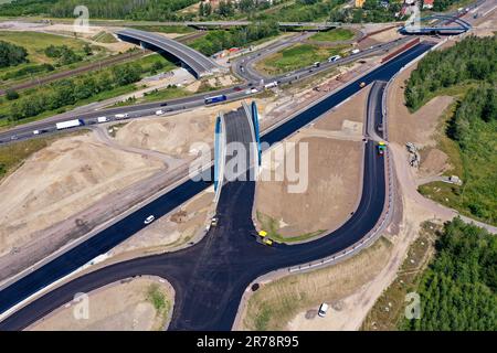 12 juin 2023, Saxe, Böhlen: La première couche d'asphalte a déjà été appliquée à la future chaussée du A72 à la jonction de Zwenkau près de Großdeuben. L'écart entre le A72 et le A38 devrait être comblé d'ici la mi-juillet. D'ici 2026, la plus grande partie de la nouvelle construction devrait être achevée et le trafic de la région de Vogtland à Leipzig pourra se déplacer sur deux voies. La construction de la fermeture de l'écart est complexe parce que la route traverse les terrains de déversement d'une ancienne mine à ciel ouvert. (Photo aérienne avec drone) photo: Jan Woitas/dpa Banque D'Images