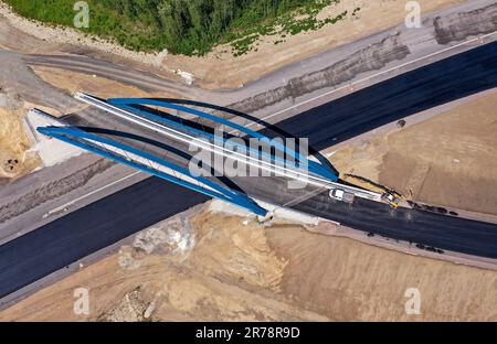 12 juin 2023, Saxe, Böhlen: La première couche d'asphalte a déjà été appliquée à la future chaussée du A72 à la jonction de Zwenkau près de Großdeuben. L'écart entre le A72 et le A38 devrait être comblé d'ici la mi-juillet. D'ici 2026, la plus grande partie de la nouvelle construction devrait être achevée et le trafic de la région de Vogtland à Leipzig pourra se déplacer sur deux voies. La construction de la fermeture de l'écart est complexe parce que la route traverse les terrains de déversement d'une ancienne mine à ciel ouvert. (Photo aérienne avec drone) photo: Jan Woitas/dpa Banque D'Images