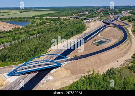 12 juin 2023, Saxe, Böhlen: La première couche d'asphalte a déjà été appliquée à la future chaussée du A72 à la jonction de Zwenkau près de Großdeuben. L'écart entre le A72 et le A38 devrait être comblé d'ici la mi-juillet. D'ici 2026, la plus grande partie de la nouvelle construction devrait être achevée et le trafic de la région de Vogtland à Leipzig pourra se déplacer sur deux voies. La construction de la fermeture de l'écart est complexe parce que la route traverse les terrains de déversement d'une ancienne mine à ciel ouvert. (Photo aérienne avec drone) photo: Jan Woitas/dpa/ZB Banque D'Images