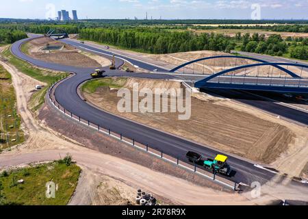 12 juin 2023, Saxe, Böhlen: La première couche d'asphalte a déjà été appliquée à la future chaussée du A72 à la jonction de Zwenkau près de Großdeuben. L'écart entre le A72 et le A38 devrait être comblé d'ici la mi-juillet. D'ici 2026, la plus grande partie de la nouvelle construction devrait être achevée et le trafic de la région de Vogtland à Leipzig pourra se déplacer sur deux voies. La construction de la fermeture de l'écart est complexe parce que la route traverse les terrains de déversement d'une ancienne mine à ciel ouvert. (Photo aérienne avec drone) photo: Jan Woitas/dpa Banque D'Images