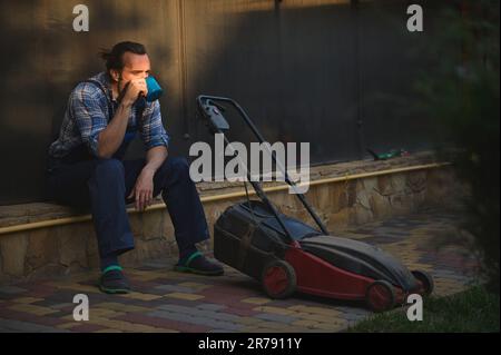 Le propriétaire d'une maison surtravaillée, un jardinier amateur, boit du café, prend une pause après une dure journée de travail. Les gens travail Hobby profession Banque D'Images