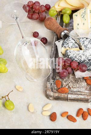 Vin rose et rouge servi avec des fromages, des noix, des raisins et des verres de vin. Délicieux repas vins divers en-cas servis à bord. Poser à plat sur un bac blanc Banque D'Images