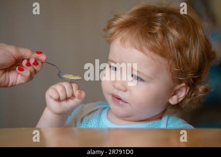 Nourrir bébé. Pas faim. Enfant refusant de manger. L'enfant n'a pas d'appétit. Un petit enfant contrarié refuse de manger de la soupe. Une alimentation saine pour les enfants. Banque D'Images