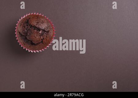 Un muffin au chocolat sur fond marron foncé, vue du dessus avec espace pour copier Banque D'Images