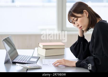 Femme asiatique préoccupée par la déclaration de revenus Banque D'Images