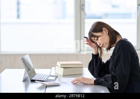 Femme asiatique préoccupée par la déclaration de revenus Banque D'Images