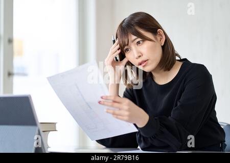 Femme asiatique préoccupée par la déclaration de revenus Banque D'Images