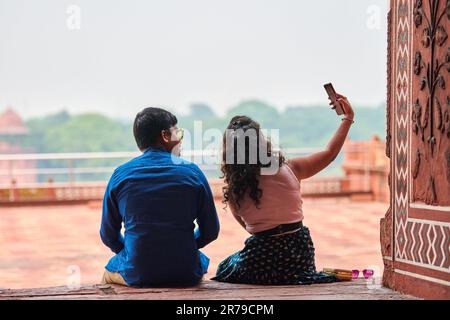 Agra, Inde - 09.11.2022 - vue arrière des amoureux de couple indien faisant le selfie près du Taj Mahal point de repère à Agra, couple indien assis ensemble et faisant Banque D'Images