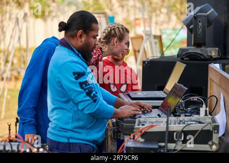 New Delhi, Inde - 10.12.2022 - DJ indien en sweat-shirt bleu travaillant à la fête extérieure avec console de mixage DJ, extérieur musique indienne partie familiale privée Banque D'Images