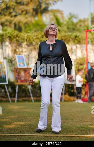 New Delhi, Inde - 10.12.2022 - Femme adulte dans le pantalon blanc et chemise noire danse à la musique sur la pelouse verte de l'arrière-cour, portrait complet du corps de la femme heureuse Banque D'Images