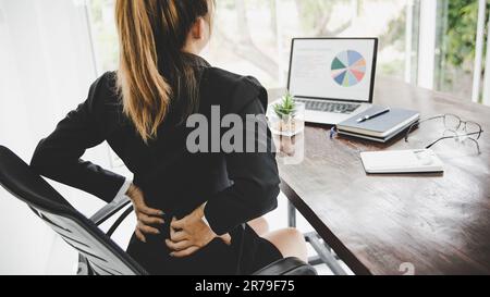Jeune femme d'affaires au bureau avec une douleur terrible de dos pendant qu'elle travaille dans le bureau .Health Problems concept Banque D'Images