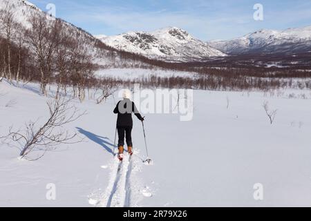 LAPONIE, SUÈDE, LE 13 MARS 2015. Randonnée non identifiée ski dans la neige récemment tombée. Montage et ensoleillement. Utilisation éditoriale. Banque D'Images