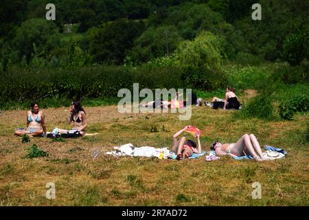 Les personnes qui bronchent à Warleigh Weir près de Bath. Le Bureau met a publié des directives indiquant que la plupart des Britanniques respecteront les critères des vagues de chaleur cette semaine, et une alerte orange pour les températures chaudes a été émise par l'Agence britannique de sécurité sanitaire (UKHSA). Date de la photo: Mercredi 14 juin 2023. Banque D'Images