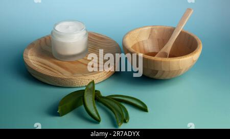 Une image d'un bol en bois rustique avec une sélection de cuillères de cuisson en bois et un petit récipient à côté Banque D'Images