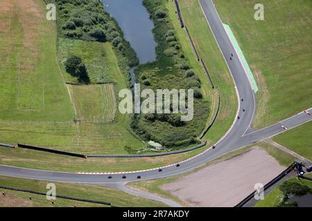 Vue aérienne d'un coin du circuit Oulton Park à Cheshire avec 6 motos entrant dans une courbe serrée Banque D'Images