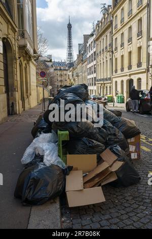 Pile d'ordures dans la rue de Paris, France avec la Tour Eiffel en arrière-plan pendant la grève de réforme des retraites. 25 mars 2023. Banque D'Images