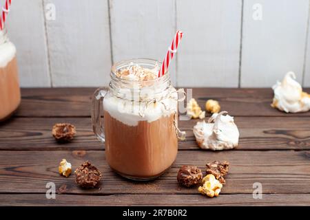 Chocolat chaud avec crème fouettée, meringues, truffes au chocolat. Boisson de confort pour les froides soirées d'automne ou d'hiver Banque D'Images