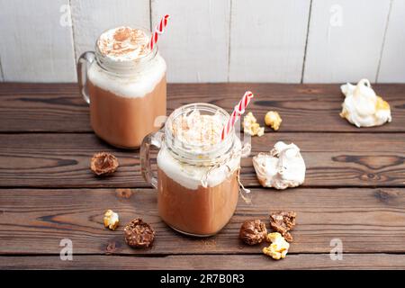 Chocolat chaud avec crème fouettée, meringues, truffes au chocolat. Boisson de confort pour les froides soirées d'automne ou d'hiver Banque D'Images