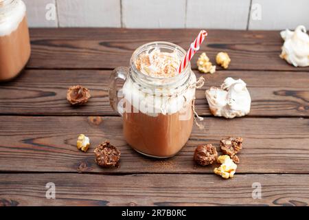 Chocolat chaud avec crème fouettée, meringues, truffes au chocolat. Boisson de confort pour les froides soirées d'automne ou d'hiver Banque D'Images