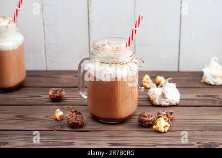 Chocolat chaud avec crème fouettée, meringues, truffes au chocolat. Boisson de confort pour les froides soirées d'automne ou d'hiver Banque D'Images