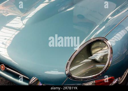 Détail du phare et du capot d'une E Type Jaguar coupé voiture de sport britannique construite entre 1961 et 1974 et conçue par Malcolm Sayer. Banque D'Images