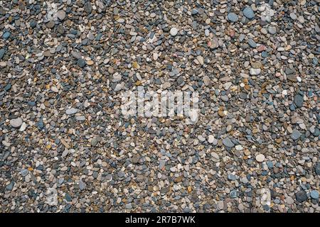 Arrière-plan de texture galet rond. Plage de galets de mer gros plan, galets ronds sombres et galets secs gris, idée de photo de haute qualité pour l'écran Banque D'Images