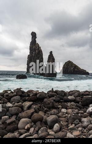 Pierres sur la côte et l'océan Atlantique sauvage avec de petites îles rocheuses près de Ribeira da Janela à Madère Banque D'Images