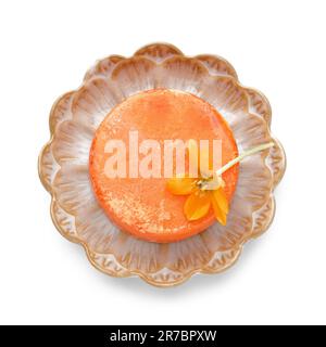 Assiette avec barre à shampoing orange et fleur sur fond blanc Banque D'Images