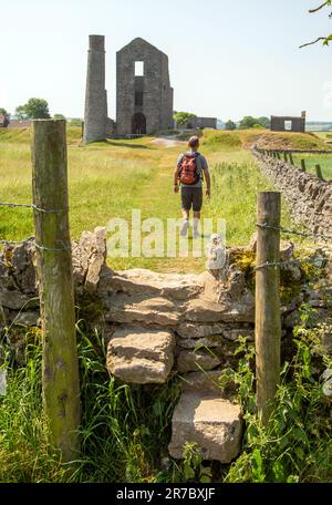 Homme marchant vers la mine Magpie, les restes d'une ancienne mine de plomb dans le Derbyshire Dales, village de Peak District de Sheldon Banque D'Images