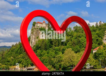 Cadre inhabituel du coeur rouge ou j'aime la statue au lac de Bled pour montrer le château de Bled sur son sommet vertical de la falaise Banque D'Images