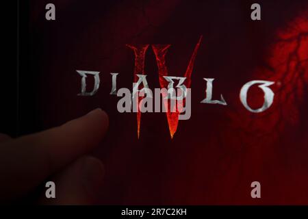 Diablo 4 logo de jeu vu sur l'écran et le doigt pointant vers lui. Diablo IV est un jeu développé par Blizzard Entertainment. Stafford, Royaume-Uni, Ju Banque D'Images