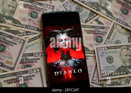 Diablo 4 affiche de jeu vu sur smartphone placé sur des billets de dollars. Diablo IV est un jeu développé par Blizzard Entertainment. Stafford, Royaume-Uni, juin Banque D'Images