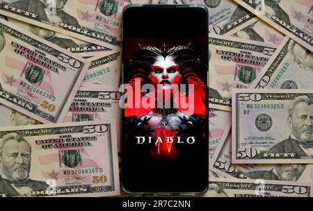 Diablo 4 affiche de jeu vu sur smartphone placé sur des billets de dollars. Diablo IV est un jeu développé par Blizzard Entertainment. Stafford, Royaume-Uni, juin Banque D'Images