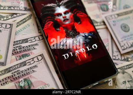 Diablo 4 affiche de jeu vu sur smartphone placé sur des billets de dollars. Diablo IV est un jeu développé par Blizzard Entertainment. Stafford, Royaume-Uni, juin Banque D'Images