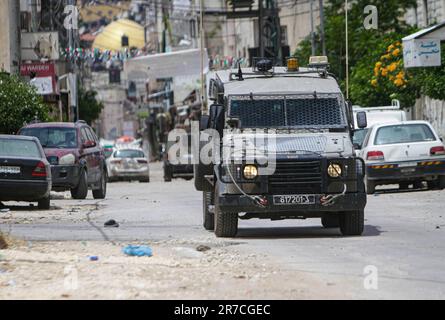 Naplouse, Palestine. 13th juin 2023. Des véhicules militaires israéliens entourent une maison, pendant la tempête du camp de réfugiés de Balata, à l'est de Naplouse, en Cisjordanie occupée. Les forces de l'armée israélienne ont attaqué le camp de réfugiés de Balata, pris d'assaut une maison et l'ont bombardée, Un palestinien de 19 ans a été tué et beaucoup d'entre eux ont été blessés. (Credit image: © Nasser Ishtayeh/SOPA Images via ZUMA Press Wire) USAGE ÉDITORIAL SEULEMENT! Non destiné À un usage commercial ! Banque D'Images