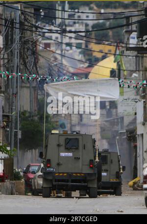 Naplouse, Palestine. 13th juin 2023. Des véhicules militaires israéliens entourent une maison pendant la tempête du camp de réfugiés de Balata, à l'est de Naplouse, en Cisjordanie occupée. Les forces de l'armée israélienne ont attaqué le camp de réfugiés de Balata, pris d'assaut une maison et l'ont bombardée, Un palestinien de 19 ans a été tué et beaucoup d'entre eux ont été blessés. (Credit image: © Nasser Ishtayeh/SOPA Images via ZUMA Press Wire) USAGE ÉDITORIAL SEULEMENT! Non destiné À un usage commercial ! Banque D'Images