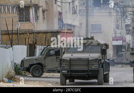 Naplouse, Palestine. 13th juin 2023. Des véhicules militaires israéliens entourent une maison pendant la tempête du camp de réfugiés de Balata, à l'est de Naplouse, en Cisjordanie occupée. Les forces de l'armée israélienne ont attaqué le camp de réfugiés de Balata, pris d'assaut une maison et l'ont bombardée, Un palestinien de 19 ans a été tué et beaucoup d'entre eux ont été blessés. (Credit image: © Nasser Ishtayeh/SOPA Images via ZUMA Press Wire) USAGE ÉDITORIAL SEULEMENT! Non destiné À un usage commercial ! Banque D'Images