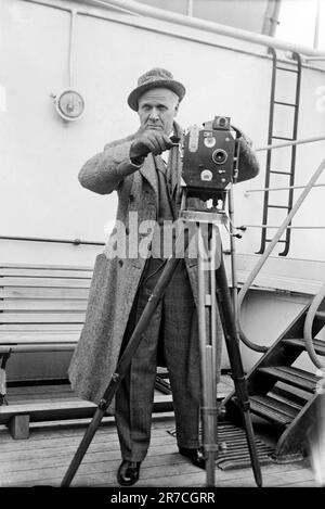 c. 1929. La chanteuse d'opéra russe Feodor Chaliapin est à bord d'un navire avec une caméra de cinéma. Banque D'Images