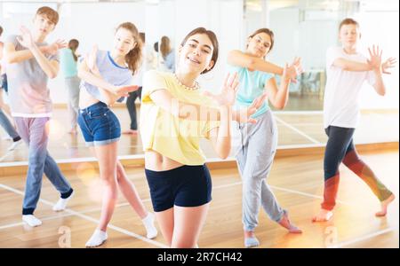 Une adolescente s'exerçant pendant un cours de danse de groupe Banque D'Images