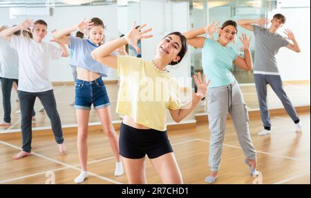 Une adolescente s'exerçant pendant un cours de danse de groupe Banque D'Images