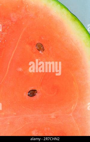 Gros plan de la tranche de pastèque juteuse. Tranche de melon mûr dans de l'eau pétillante, gros plan. Image macro verticale. Banque D'Images