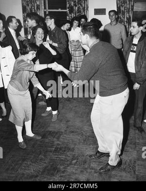 États-Unis: c. 1957 Un couple de swing dansant à une fête. Banque D'Images