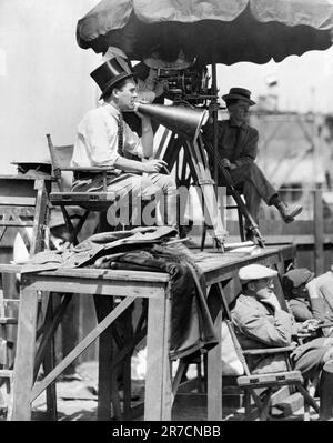 Hollywood, Californie: 1921 Directeur Rex Ingram avec mégaphone, cigare, chapeau haut et bottes hauteur genou à l'œuvre sur le set de "les quatre cavaliers de l'Apocalypse" avec Rudolph Valentino. Banque D'Images