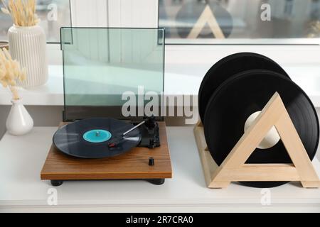 Disques en vinyle et lecteur sur table en bois blanc à l'intérieur Banque D'Images