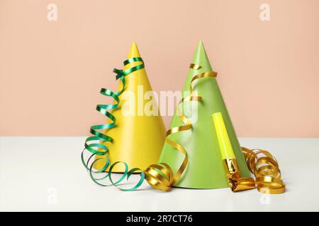 Chapeaux de fête colorés, banderoles et souffleur sur table blanche. Fête d'anniversaire Banque D'Images