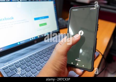 Managua, Nicaragua, 14 juin: Latino homme se connectant à facebook sur son téléphone portable Banque D'Images